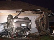 SUV Flips Into 2 Garages; Man Dies