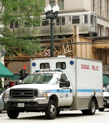 A Chicago Police Department criminal transport truck is seen under a passing CTA elevated transit train July 22, 2005 in downtown Chicago.