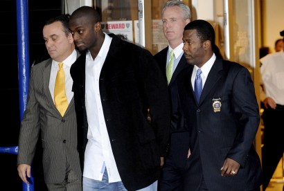 Plaxico Burress is led to a squad car for transport to his arraignment outside the NYPD's 17th Precinct today.