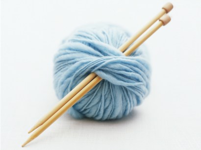 Knitting needles in ball of yarn