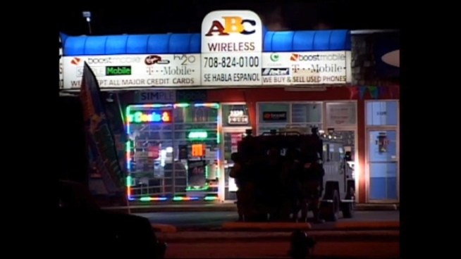 A four-hour standoff at a cell phone store in south suburban Midlothian ended with SWAT team smoke bombs, a trashed store and two arrests. Anthony Ponce reports.