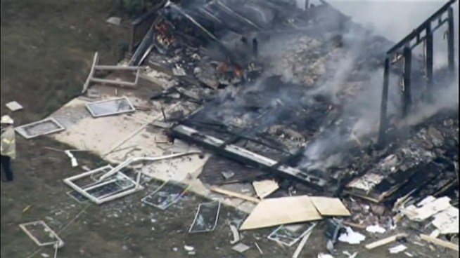 Firefighters worked to put out the flames caused by an explosion that leveled a home in Manhattan, Ill.