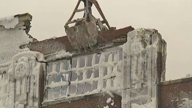 Even with portions still smoldering, crews on Friday morning began tearing down a vacant warehouse that was destroyed by fire and then encased in ice. Charlie Wojciechowski reports.