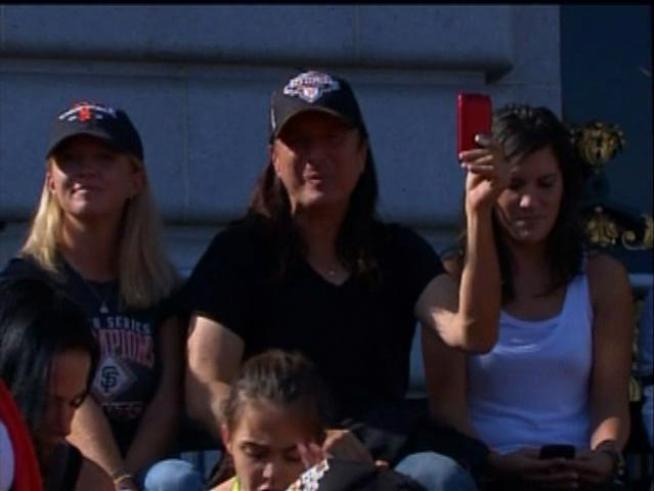 Giants fans celebrate at the victory parade in song.