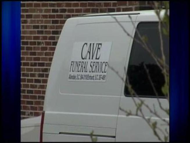 Authorities exhumed a tall man's body yesterday to determine if, in fact, a North Carolina funeral home cut the legs off a corpse.
