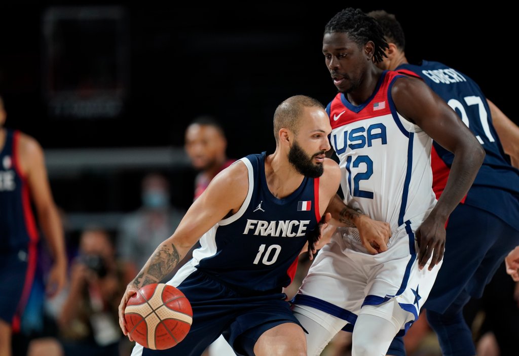 France's Evan Fournier (10) drives past United States' Jrue Holiday (12) during Men's Basketball gold medal game at the 2020 Olympics, Saturday, Aug. 7, 2021, in Saitama, Japan.