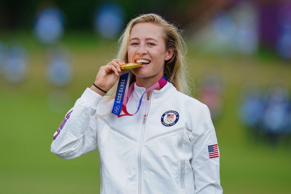 Gold medallist Nelly Korda of Team USA bites her medal on the podium during the victory ceremony of the women's golf individual stroke play during the Tokyo 2020 Olympic Games at the Kasumigaseki Country Club in Kawagoe on Aug. 7, 2021.