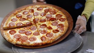 In this Nov. 18, 2011, file photo, Terry Cheung prepares a pizza pie to be served to students at Everglades High School in Miramar, Florida. Pi Day is Sunday, March 14, 2021.