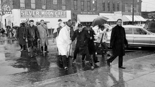 In this March 1, 1965 file photo Dr. Martin Luther King Jr. hops over a puddle as it rains in Selma, Ala. King led hundreds of African Americans to the court house in a voter registration drive.