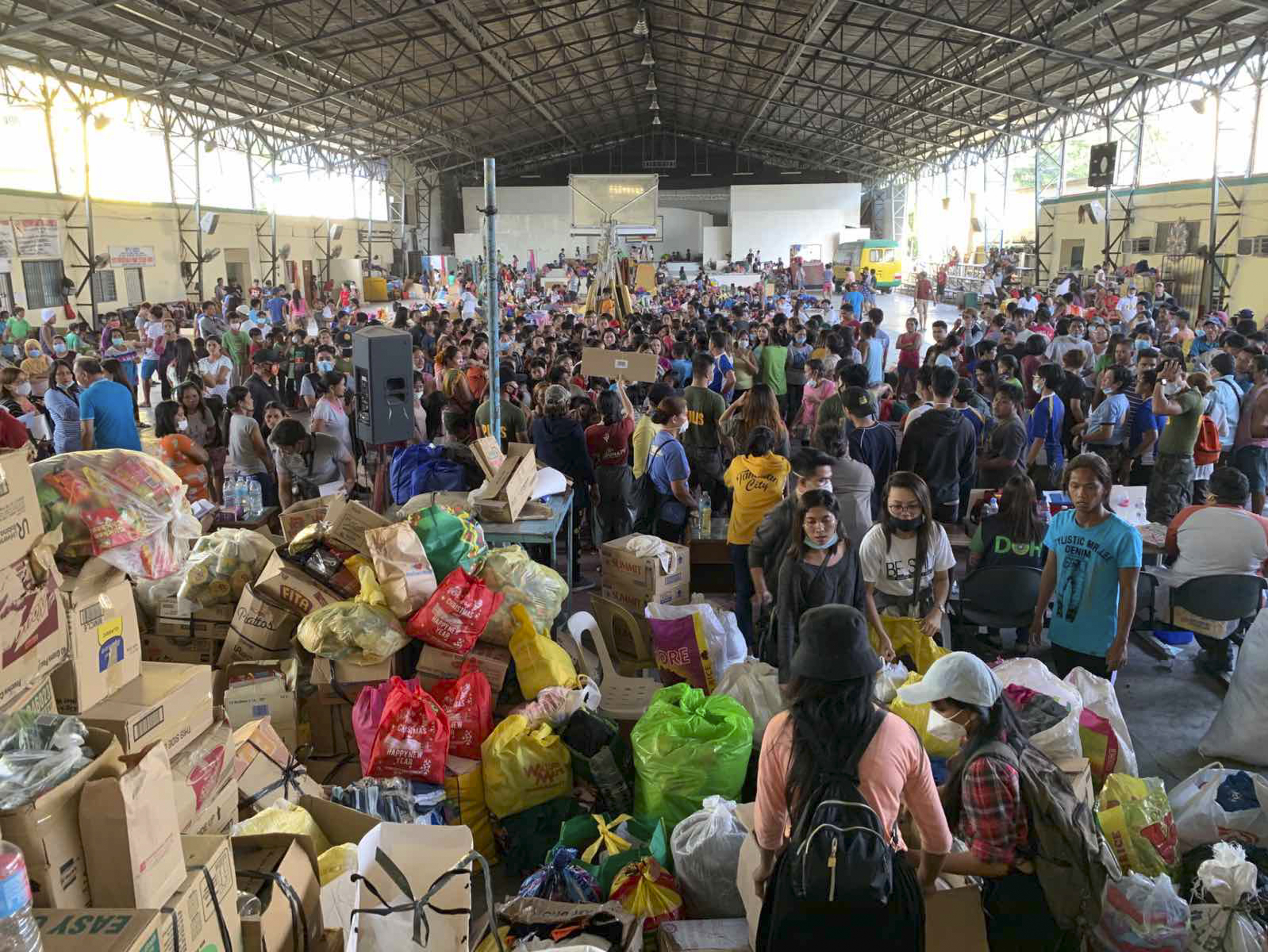 Evacuees stay at an evacuation center in Tanaun, Philippines, Jan. 14, 2020. The Taal Volcano is spewed ash half a mile high and continues to tremble with earthquakes as thousands of people flee villages darkened and blanketed by heavy ash.