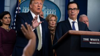 In this March 17, 2020, file photo, Treasury Secretary Steven Mnuchin, right, listens as President Donald Trump speaks during a press briefing with the coronavirus task force at the White House in Washington.