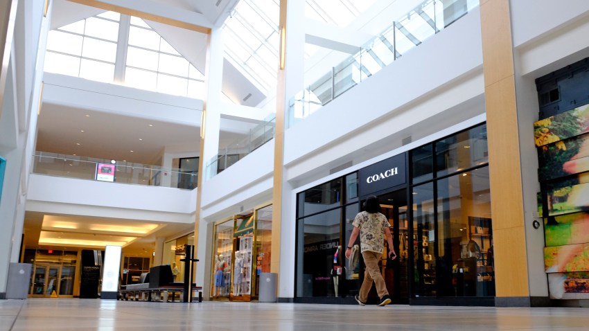 A visitor walks in an empty hallway at The Fashion Mall at Keystone, Wednesday, March 18, 2020, in Indianapolis.