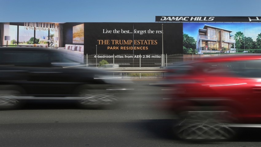 cars pass a giant billboard adverting DAMAC Properties' Trump Estates golf course villas in Dubai