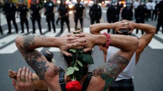 Protesters kneel in front of New York City Police Department officers