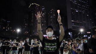 Participants gesture with five fingers, signifying the "Five demands - not one less" during a vigil for the victims of the 1989 Tiananmen Square Massacre at Victoria Park in Causeway Bay, Hong Kong, Thursday, June 4, 2020. China is tightening controls over dissidents while pro-democracy activists in Hong Kong and elsewhere try to mark the 31st anniversary of the crushing of the pro-democracy movement in Beijing's Tiananmen Square.