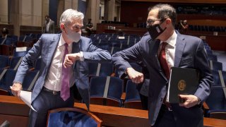 Federal Reserve Board Chairman Jerome Powell, left, and Treasury Secretary Stephen Mnuchin, bump elbows at the conclusion of a House Committee on Financial Services hearing on oversight of the Treasury Department and Federal Reserve pandemic response, Tuesday, June 30, 2020 on Capitol Hill in Washington.