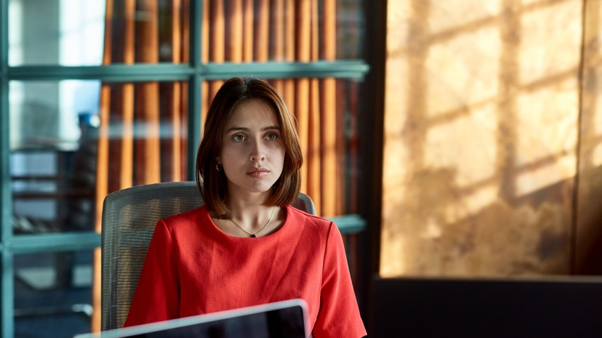 Young businesswoman sitting alone in boardroom