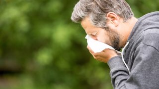 Man Sneezing By Tree