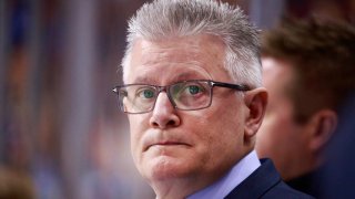 Chicago Blackhawks assistant coach Marc Crawford stands on the bench during a March 20th game in Vancouver.