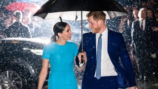 Prince Harry and Meghan under an umbrella