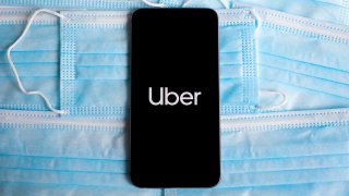 Uber logo is displayed on a mobile phone screen