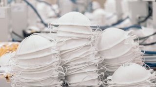 In this May 26, 2020, file photo, a pile of N95 masks sit stacked on a table at the High Technology in Air Filtration (ATFIL) manufacturing facility in Xochimilco, Mexico City, Mexico.