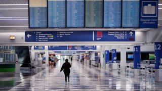 A worker walks through a baggage claim area at a nearly-empty O'Hare International Airport