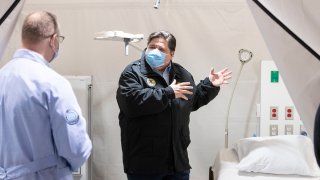 CHICAGO, ILLINOIS – APRIL 17: Illinois Gov. J.B. Pritzker (R) tours one of the patient rooms at the COVID-19 alternate care facility constructed at the McCormick Place convention center in Chicago, Illinois on April 17, 2020 in Chicago, Illinois. The facility, which began seeing patients Thursday, will serve as a primary care facility for patients with mild or moderate COVID-19 symptoms but also has isolation areas for more severe cases. (Photo by Tyler LaRiviere – Pool/Getty Images)
