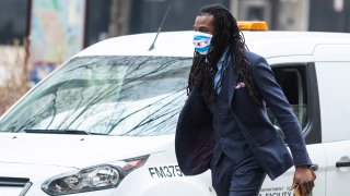 A person wearing a face mask walks down a mostly dormant Michigan Avenue