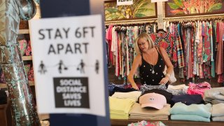In this May 4, 2020, file photo, Beth Beall shops at the Tommy Bahamas store in Stuart, Florida, as the state enters phase one of the plan to reopen.