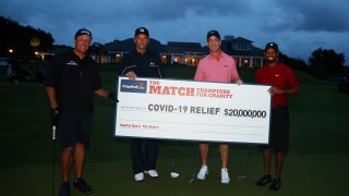 Tiger Woods and former NFL player Peyton Manning celebrate defeating Phil Mickelson and NFL player Tom Brady of the Tampa Bay Buccaneers on the 18th green during The Match: Champions For Charity at Medalist Golf Club on May 24, 2020 in Hobe Sound, Florida.