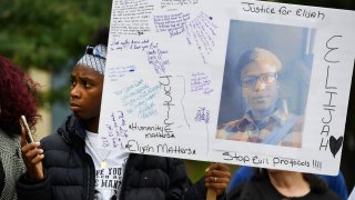 In this Oct. 1, 2019, file photo, Rashiaa Veal holds a sign featuring her cousin, Elijah McClain, at a news conference in front of the Aurora Municipal Center in Aurora, Colorado.