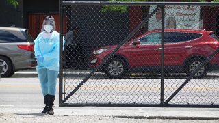 A worker directs residents at a mobile COVID-19 testing site set up on a vacant lot in the Austin neighborhood