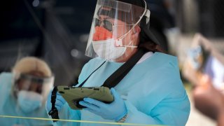 Workers check in residents at a mobile COVID-19 testing site