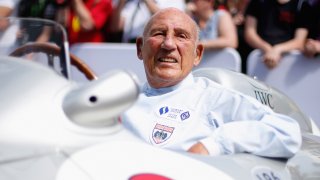 Sir Stirling Moss sits in his Mercedes