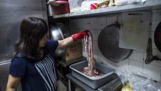 Chow Ka-ling, owner of Shia Wong Hip snake restaurant, handles snake meat in the restaurant's kitchen in the Sham Shui Po district of Hong Kong, China, on Oct. 19, 2015.
