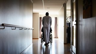 View of male nurse pushing senior man on wheelchair