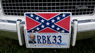 A confederate flag license plate is seen on a Cadillac.
