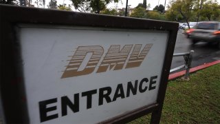 A white sign reads "DMV Entrance" as a car is seen in the background
