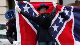 A Mississippi Highway Safety Patrol honor guard carefully folds the retired Mississippi state flag after it was raised over the Capitol grounds one final time in Jackson, Miss., Wednesday, July 1, 2020. The banner was the last state flag with the Confederate battle emblem on it.