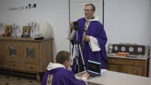 Priest Philippe Rochas, left, and Jean-Benoit de Beauchene pack up livestreaming equipment after holding a closed door Sunday mass at the St. Vincent de Paul church in Marseille, southern France, Sunday, March 22, 2020. As mass gatherings are forbidden due to measures to prevent the spread of COVID- 19, priests are using technology to reach worshippers forced to stay at home. For most people, the new coronavirus causes only mild or moderate symptoms. (AP Photo/Daniel Cole)
