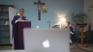 Priest Philippe Rochas of the St. Vincent de Paul church in Marseille delivers a sermon to livestream viewers during a closed door Sunday mass in Marseille, southern France, Sunday, March 22, 2020. As mass gatherings are forbidden due to measures to prevent the spread of COVID- 19, priests are using technology to reach worshippers forced to stay at home. For most people, the new coronavirus causes only mild or moderate symptoms. (AP Photo/Daniel Cole)