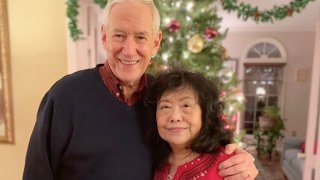 In this December, 2018 photo released by the Stemberger family, Victor and his wife Han Stemberger, are shown at their home in Centreville, Va. Victor Stemberger sits in a Spanish jail, one year after flying into the country with 2.4 kilograms (more than 5 pounds) of cocaine expertly sewn into bubble jackets in a bag. His family says he knew nothing about the drugs.