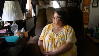 In this June 29, 2020, file photo, Doris Kelly, 57, sits in her home in Ruffs Dale, Pa. Kelly was one of the first patients in a UPMC trial for COVID-19.