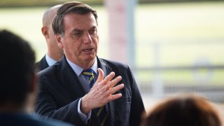 President of Brazil Jair Bolsonaro talks to supporters of his government who waited for him outside the Palácio do Alvorada amidst the coronavirus (COVID-19) pandemic on May 6, 2020 in Brasilia.