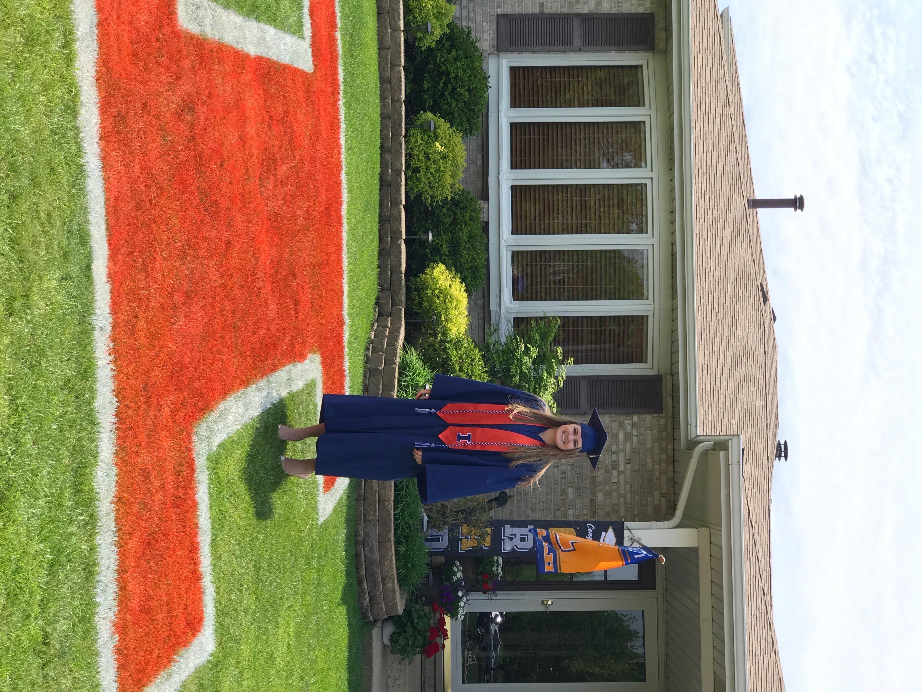 Brooke Meyer stands on her front lawn beside the “Block I” logo from the University to celebrate her graduation.