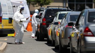 Medical workers take down personal information from those driving in to take a COVID-19 test at a Coronavirus testing location in the Cambridge Health Alliance Testing Tent in Cambridge, MA on June 18, 2020. Massachusetts has launched more than 50 pop-up coronavirus test sites to provide free testing for people who participated in large gatherings or protests.