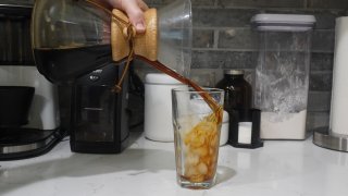 Cold brew coffee is poured into a glass with ice