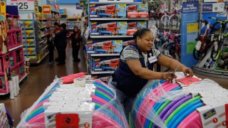 FILE – In this Nov. 27, 2019, file photo Balo Balogun labels items in preparation for a holiday sale at a Walmart Supercenter in Las Vegas. On Friday, Dec. 6, the U.S. government issues the November jobs report.