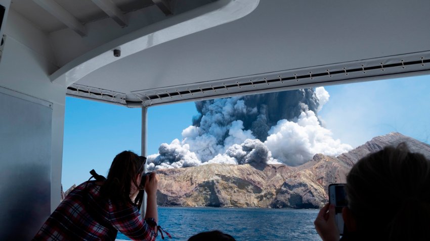 In this Dec. 9, 2019, photo provided by Michael Schade, tourists on a boat look at the eruption of the volcano on White Island, New Zealand. Unstable conditions continued to hamper rescue workers from searching for people missing and feared dead after the volcano off the New Zealand coast erupted in a towering blast of ash and scalding steam while dozens of tourists explored its moon-like surface.